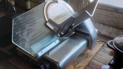 a large slicer that is sitting on a wooden table
