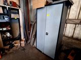 a metal cabinet in a garage with a door open