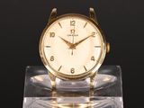 an image of a gold watch sitting on a clear stand