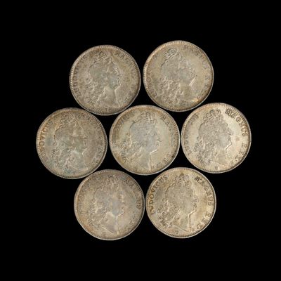 six pièces d'argent sont disposées en cercle sur un fond noir