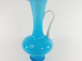 blue glass vase with a white handle on a white background