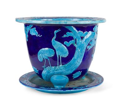 un vase bleu orné d'un oiseau, posé sur une soucoupe