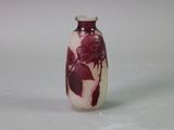 a red and white vase sitting on a white surface