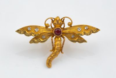 an image of a gold dragonfly brooch with diamonds on it
