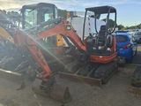 an image of a small excavator parked in a parking lot