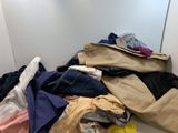 un tas de vêtements par terre, à côté d'un miroir