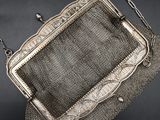 an antique silver mesh purse with a chain around it