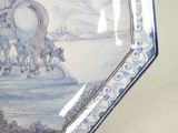 a blue and white plate with a picture of a man on a horse