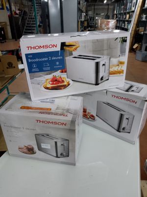 Trois cartons de grille-pain sont empilés sur une table dans un magasin.