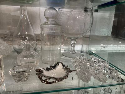 une étagère en verre sur laquelle sont posés de nombreux objets en verre
