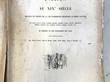 un vieux livre posé sur une table à côté d'un livre ouvert