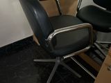 une chaise noire posée à côté d'un bureau dans une pièce