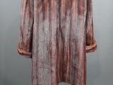 a brown and black fur coat on a mannequin stand
