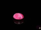 a picture of a pink stone on a black surface