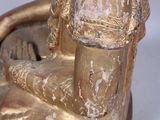 a gold statue of a woman sitting on a chair