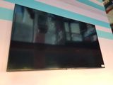La télévision à écran plat est accrochée au mur de la pièce.