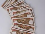 five bills of mexican currency laid out on a white surface