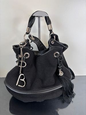 the black purse is sitting on top of a black table