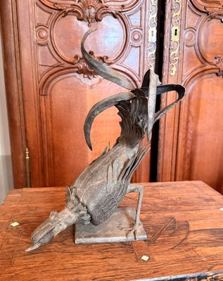 une statue représentant un oiseau posée sur une table en bois