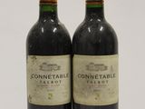 two bottles of wine sitting next to each other on a table