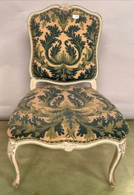 une vieille chaise dont le dossier est recouvert d'un tissu bleu et vert
