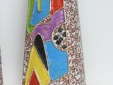two vases with colorful designs on them on a white surface