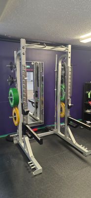 une salle de sport équipée d'un support pour haltères et d'appareils de musculation
