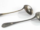 two spoons that are sitting next to each other on a table