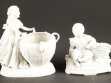 deux figurines représentant un garçon et une fille avec un panier