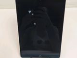 the tablet is sitting on a white surface with a hand resting on it
