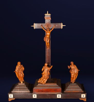 un crucifix ancien en bois comportant trois figurines représentant Jésus sur la croix