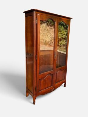 une image d'une armoire en bois avec une porte en verre