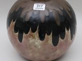 a black and brown vase with a tag on it