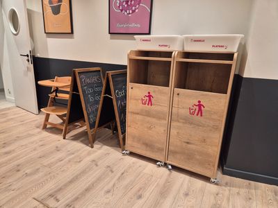 des tables et des chaises dans une pièce où se trouve un tableau noir accroché au mur