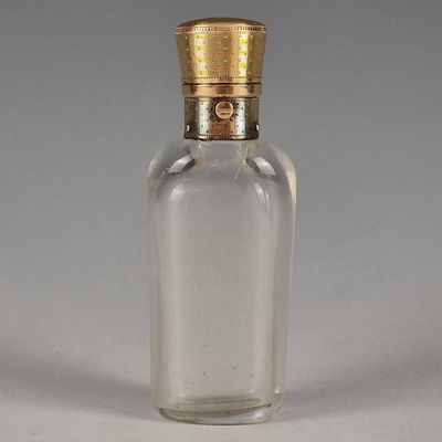 une petite bouteille en verre munie d'un bouchon doré