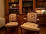 two chairs that are sitting in front of a bookshelf