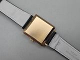 a close up of a watch on a white surface with a black band