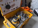 une boîte à outils jaune posée par terre, contenant des outils
