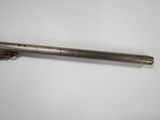 an old metal pipe with a wooden handle on a white surface