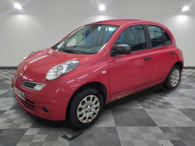 la petite voiture rouge est garée dans le garage sur un sol en damier