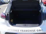 the back of a white car with its trunk open in a parking lot