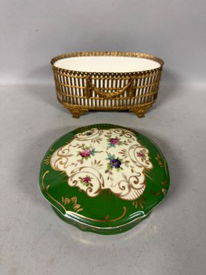an image of a green and gold box with a basket on top