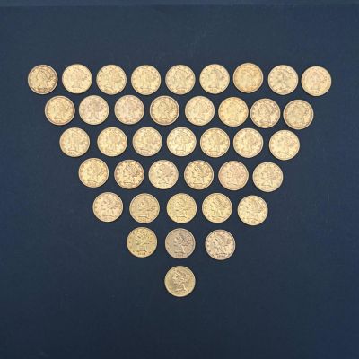des pièces d'or disposées en forme de cœur sur un fond noir