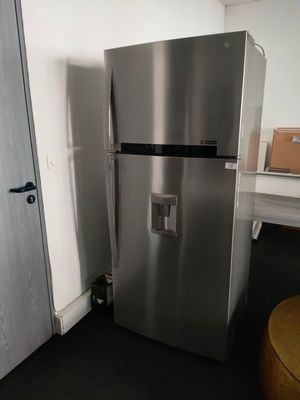 a silver refrigerator next to a white door in a room