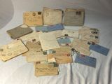 une pile de vieilles lettres et d'enveloppes posée sur un lit