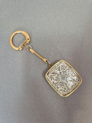 une image représentant un porte-clés en or orné d'un motif carré
