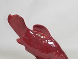 a red bird figurine sitting on top of a white table
