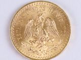 a gold coin with an eagle on it on a white surface