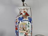 une lampe posée sur une table sur laquelle se trouve une photo