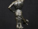 a bronze statue of a man holding a tennis racquet